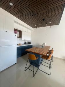 a kitchen with a wooden table and a refrigerator at Bello Departamento in Mexicali +24 photos