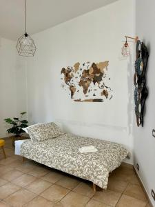 a bedroom with a bed and a map on the wall at La casetta triangolare in Bernalda
