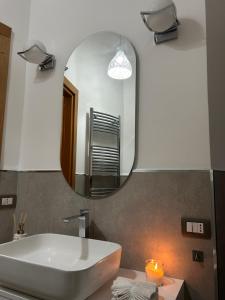 a bathroom with a sink and a mirror at La casetta triangolare in Bernalda +26 photos