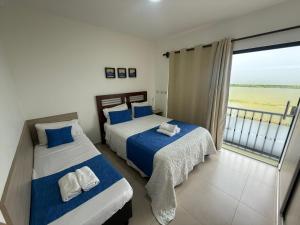 two beds in a room with a view of the ocean at Nerea-Casa de Playa en Condominio Mar Adentro in Naranjalito +35 photos