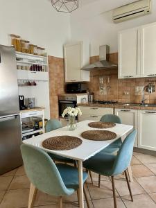 a kitchen with a table and chairs and a kitchen with white cabinets at La casetta triangolare in Bernalda