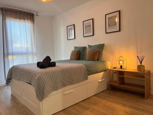 a bedroom with a bed with a night stand next to a window at T2 Cosy avec Terrasse & 2 parkings privés in Saint-André-de-Cubzac