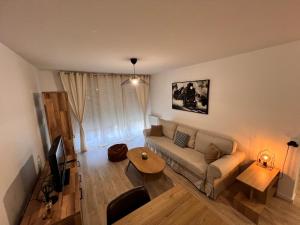 a living room with a couch and a table at T2 Cosy avec Terrasse & 2 parkings privés in Saint-André-de-Cubzac