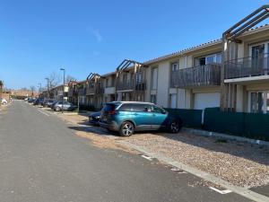 a blue car parked next to a row of houses at T2 Cosy avec Terrasse & 2 parkings privés in Saint-André-de-Cubzac