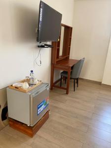 a room with a television and a table with a table at Hotel Monte Verde in Beira