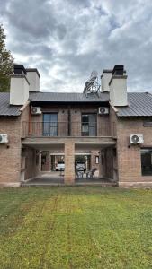 a large brick house with a balcony and a yard at Terroir Village - Complejo en Mendoza in Guaymallen