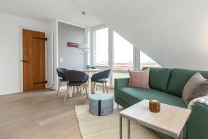 a living room with a green couch and a table at Lee in Juist
