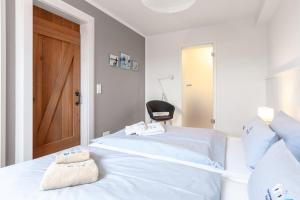 a bedroom with a bed with a chair and a door at Lee in Juist