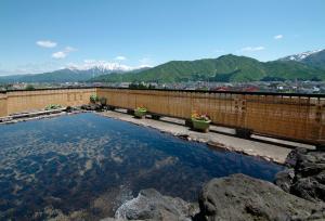 a large pool of water with mountains in the background at Hotel Kinomezaka in Minami Uonuma