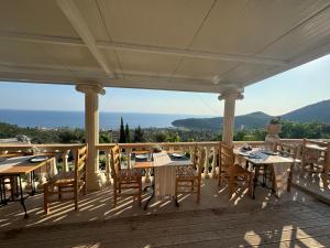 a patio with tables and chairs on a deck at Persephone in Himare