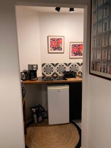 a kitchen with a small white refrigerator in a room at 3- Le saule mauve in Poitiers
