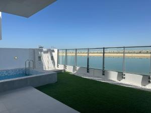 Blick auf den Pool vom Balkon eines Gebäudes in der Unterkunft Beachfront Villa with Heated Private Pool & Jacuzzi in Al Ḩamrīyah