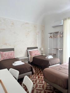 a room with three beds and a couch at Il Teatro Rooms in Catania