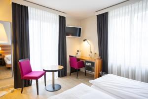 a hotel room with a bed and a table and chairs at Hotel Astoria in Olten