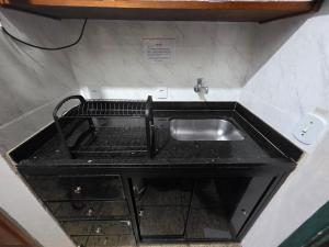 a kitchen sink with a black counter top at PERÓ BEIRA MAR - Flat âncora - 203A in Cabo Frio