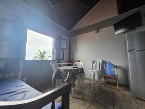 a bedroom with a table and chairs and a refrigerator at PERÓ BEIRA MAR - Flat âncora - 203A in Cabo Frio