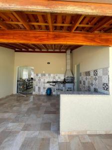 a large room with a kitchen in a house at Apartamento em Poços - Varanda com Churrasqueira in Poços de Caldas
