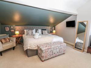 a bedroom with a bed and a chair and a mirror at Hillside View in Hawes