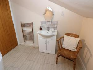 a bathroom with a sink and a chair and a mirror at Hillside View in Hawes +25 photos