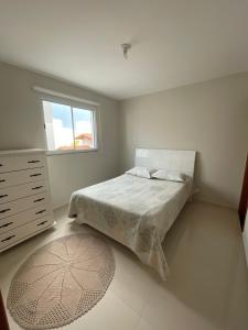 a bedroom with a bed and a window and a rug at Apartamento em Poços - Varanda com Churrasqueira in Poços de Caldas