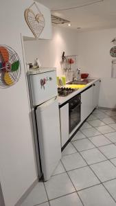 a kitchen with a white refrigerator and a stove at LV SWAN Apartment in Carloforte +9 photos