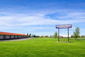 a sign in a field next to a building at Northern Lights Inn & Suites in Valleyview