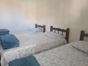 a room with three beds with blue towels on them at Casa do Lago Triunfo in Triunfo