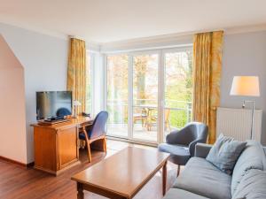 a living room with a couch and a tv at Hof Sierksdorf in Sierksdorf