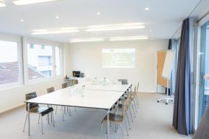 a conference room with a white table and chairs at Hotel Astoria in Olten