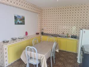 a kitchen with a table and yellow cabinets and a refrigerator at Casa do Lago Triunfo in Triunfo +14 photos