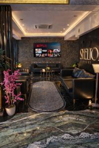 a lobby with leather couches and a table at Shelton Airport Hotel in Arnavutköy