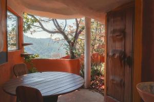 a table and chairs on a porch with a window at El encinal in San Miguel
