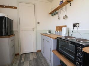 a kitchen with white cabinets and a black stove at Shepherds Delight in Macclesfield +11 photos