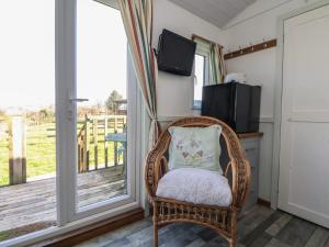 a wicker chair with a pillow sitting on a porch at Shepherds Delight in Macclesfield