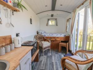 a kitchen with a desk and chairs in a tiny house at Shepherds Delight in Macclesfield