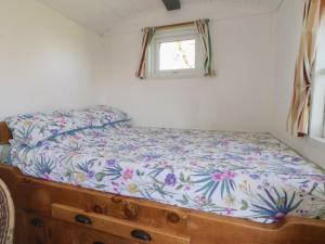 a bed in a small room with a flower pattern on it at Shepherds Delight in Macclesfield