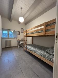 a bedroom with two bunk beds and a desk at Maison Cavallino in Lugo