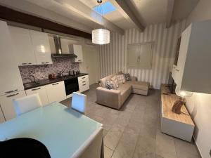 a kitchen and living room with a couch and a table at Maison Cavallino in Lugo