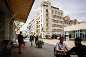 a group of people walking down a city street at Hotel Astoria in Olten +32 photos