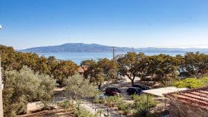 a parking lot with trees and a view of the water at Sivrice Sarnıç in Behramkale
