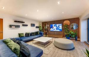 a living room with a blue couch and a tv at Lincoln 4-Beds Sleeps 13 Hot Tub & Pet Friendly in Lincoln