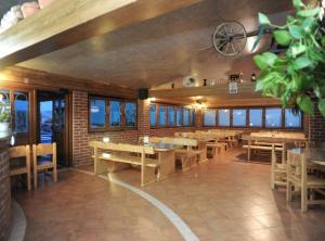 a restaurant with wooden tables and chairs and windows at Golden Coast Villa Caska in Novalja