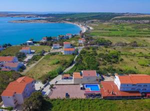 an aerial view of a house on a hill next to the water at Golden Coast Villa Caska in Novalja