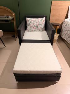 a bed in a room with a couch with a pillow at Flat Romance Praia e Home Office in São Vicente +17 photos