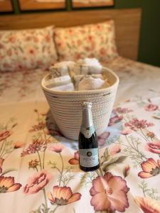 a bottle of wine on a bed with a basket of towels at Flat Romance Praia e Home Office in São Vicente