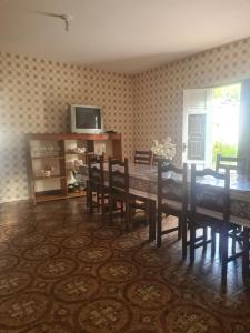 a dining room with a table and chairs and a television at Casa do Lago Triunfo in Triunfo