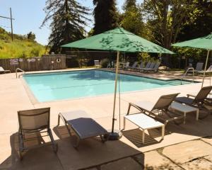 a group of chairs and an umbrella next to a pool at El Capitan Canyon in Capitan