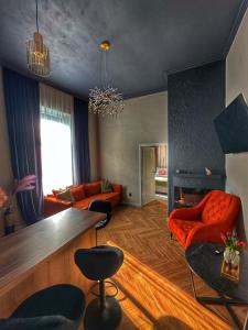 a living room with orange furniture and a fireplace at Euphoria Apartments in Beiuş