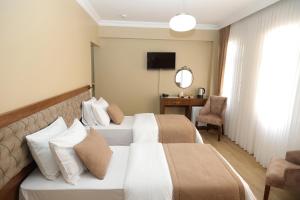ein Hotelzimmer mit zwei Betten und einem Schreibtisch in der Unterkunft Ramparts Hotel in Istanbul