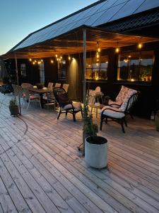 a deck with chairs and a table and a tent at Villa Golfgatan 32 Vintrosa Lanna in Vintrosa